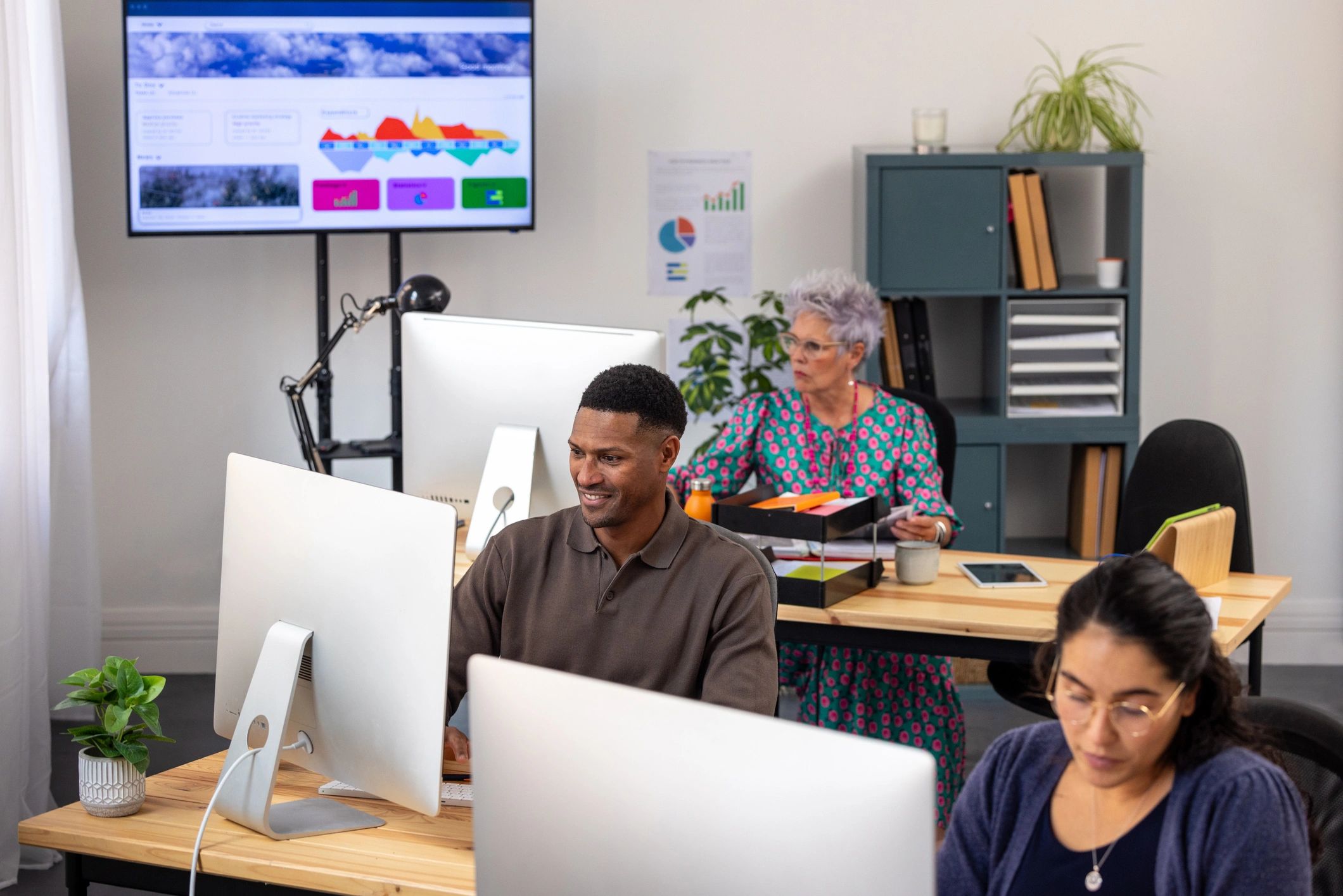 Office team reviewing supplier information on screens