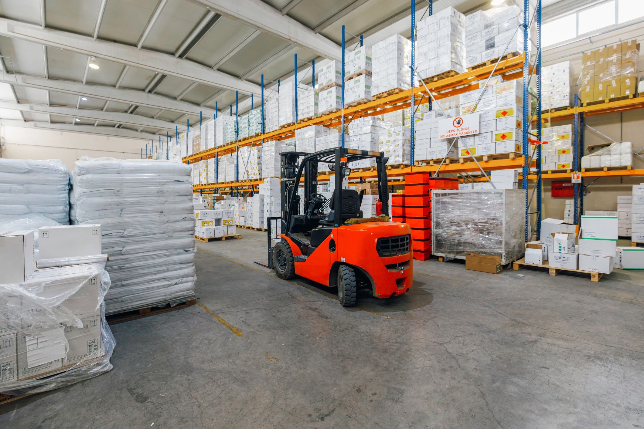 Forklift operating in a large warehouse aisle